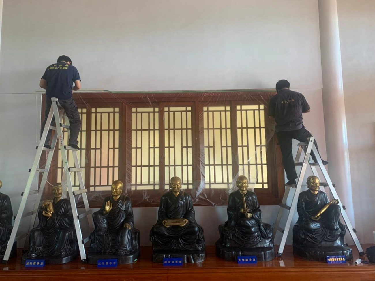 觀音禪寺：兩位師傅架梯處理佛像後方木格窗