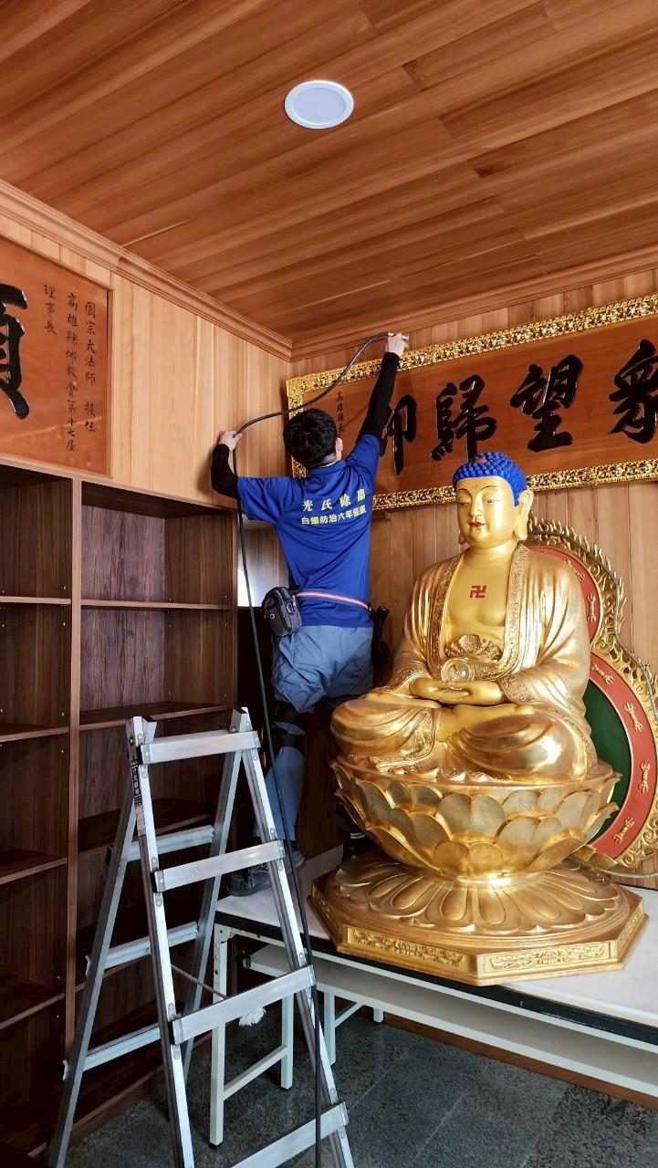 日月禪寺佛堂：師傅站上鋁梯處理木作天花板與佛像上方