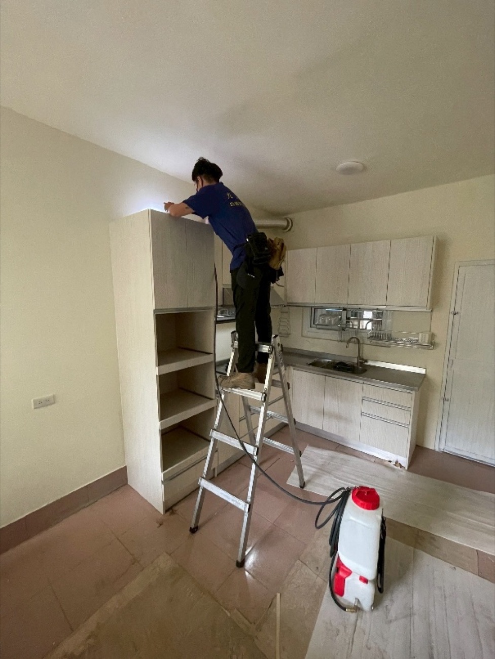 新廚具安裝後，站上鋁梯處理吊櫃上方